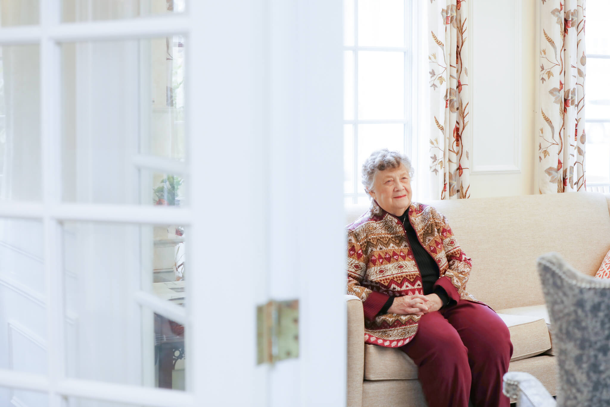 Lilian Warner Sitting on Couch in a Sunny Room